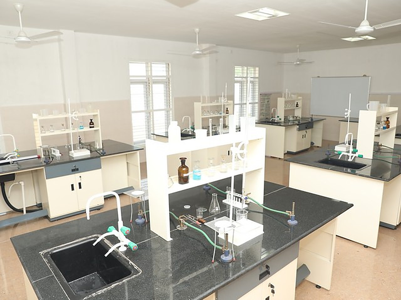 The chemistry laboratory, benches with sinks and glassware