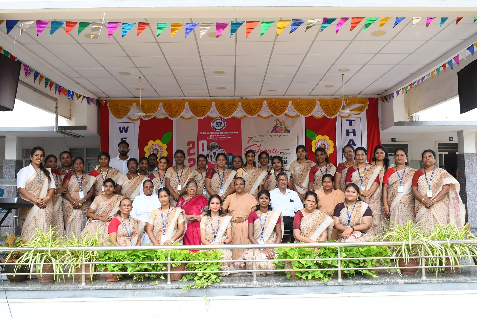 The staff of Our Lady School of Excellence — teachers and the Salesian Sisters — gathered on the decorated stage